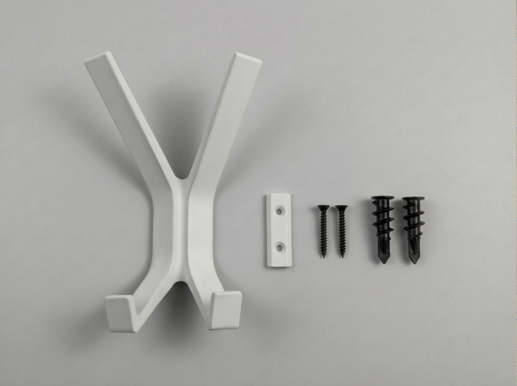 White modern Garuda-X coat hanger with screws on a gray background.