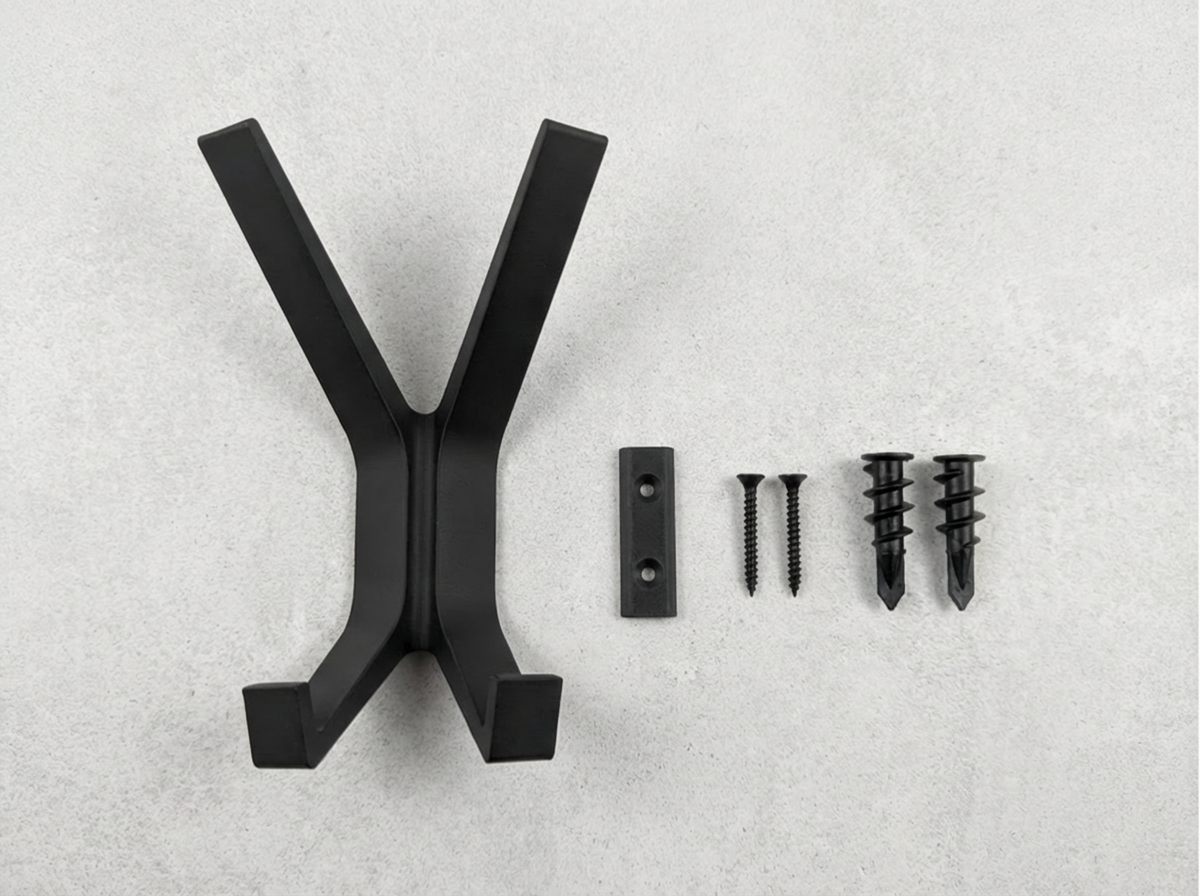 Black Garuda X shaped coat hanger with screws on a gray background.