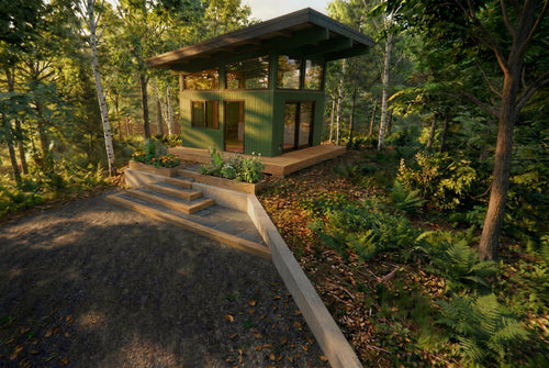 Exterior view of a modern ceramics studio situated in dense woodland, designed with a mono‑pitched roof, deep overhangs, and expansive multi‑panel glazing that frames immersive forest views. The green‑clad structure recedes quietly into the landscape, while an integrated wooden deck and concrete steps connect the light‑filled, highly functional interior workspace to its natural surroundings.